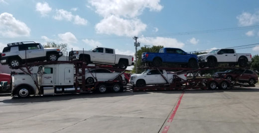 photo of a black car on a trailer truck